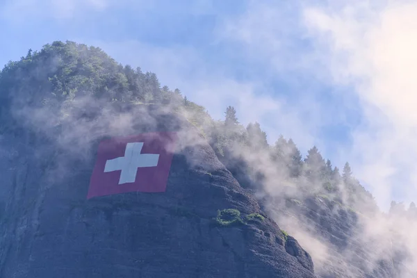 Bandiera svizzera sul fianco della montagna — Foto Stock