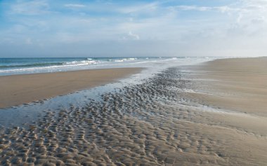 Hollanda, Terschelling 'in ıslak bir sahilinde dalgalar