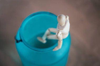 Uçurumun eşiğinde. Yalnızlık. Kenarda oturan tahta bir adamın heykelciği. Psikolojik deneyimler hakkında kavramsal imaj.