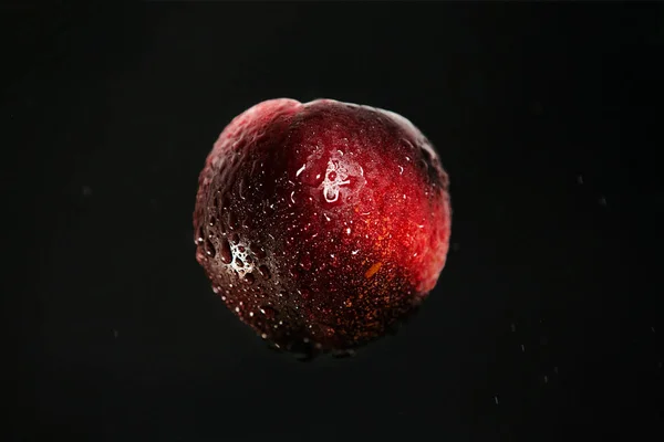 Flying fresh peach on black background. Concept of food levitation