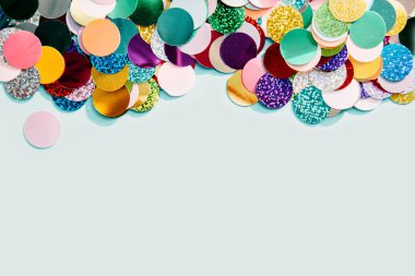 Mavi arka plan üzerinde parlak renkli konfeti, üst görünüm