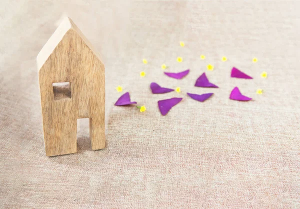 エコ背景に紫色の葉と黄色の花を持つ木製のおもちゃの家 トップビュー エコフレンドリーな家のコンセプト — ストック写真