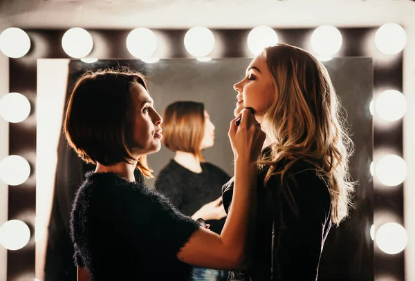 Junge Frauen beim Make-up, altmodisch. steht in der Nähe von Spiegel. Backstage. — Stockfoto