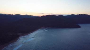 Gün batımı plajı dağlar ve dalgalarla 34k 24 fps