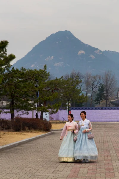 韓国の伝統衣装 韓服を着て つの女性観光客がバック グラウンドで美しい山で宮殿に散歩をして景福宮 ソウル 2018 — ストック写真