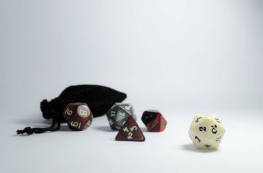 Bazı rpg zar ve küçük siyah bir çanta, beyaz bir arka planda yaymak. Rol yapma oyunu ve zindanlar ve ejderhalar zar.