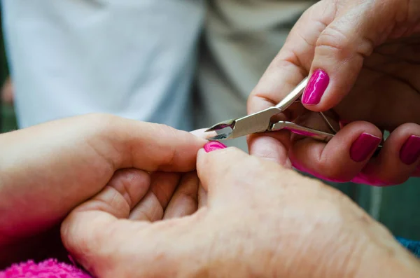 having the nails done with beautiful pink colors using nail cutt