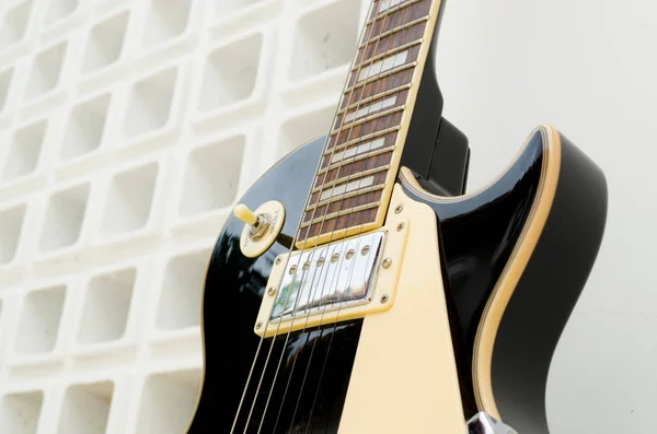 Vücudun Bir Kısmını Gösteren Beyaz Bir Arka Planda Siyah Gitar — Stok fotoğraf