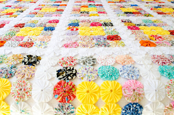 several pieces of Fuxico sewn together forming a bedspread. handmade. artisanal. craft. colorful.