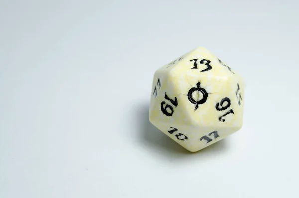 twenty-sided dice, isolated on a white background. Face of number twenty in focus. dice of role playing game and dungeons and dragons.