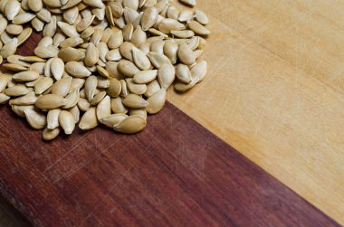 Kabak tohumları iki renk ile ahşap bir yüzeye yığılmış