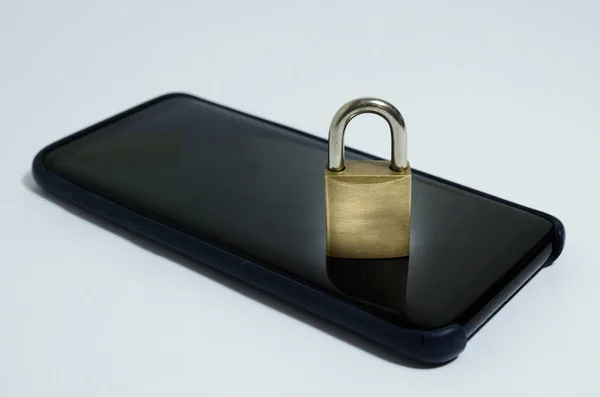 Conceptual photo security on mobile phones. A closed padlock on a cell phone on a white background