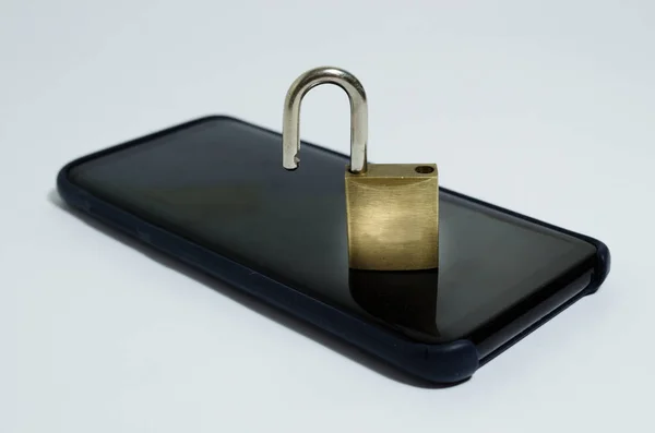 Conceptual photo security on mobile phones. A open padlock on a cell phone on a white background. — Stock Photo, Image