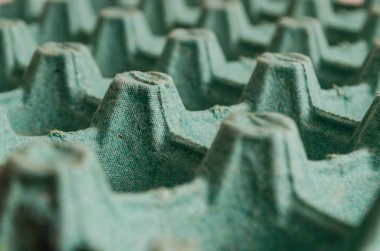 delik ve yükseklikleri ile bir desen oluşturan açık boş yumurta yeşil ambalaj.