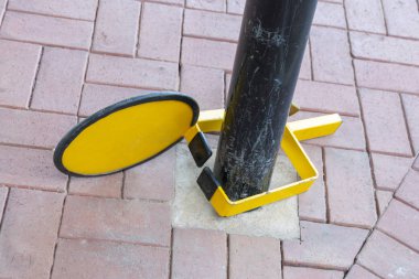 vasiyetle sıkma sarı ve siyah araba tekerleğin arka görünümü kadar yakın direğe sınırlı Park alanının yanındaki kilitli 