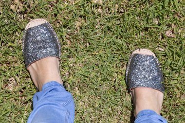 Yeşil çimenlerin üzerinde kadın glitter ayakkabı dışında görünümü kadar yakın 