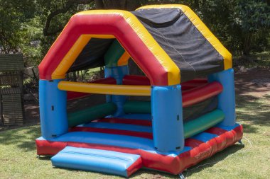 A Close up view of a very colourful blown up jumping castle in the back garden  clipart