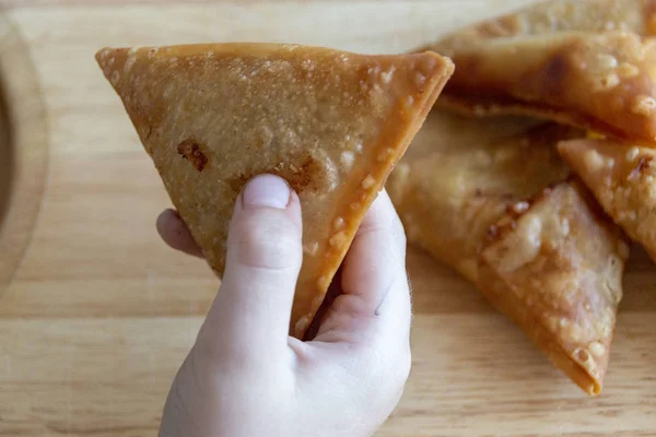 elinde yemek için hazır bir samosa tutan bir çocuğun yakın görünümü