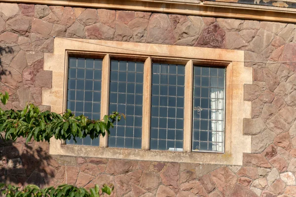 A close up view of a glass window on the side of a stone house