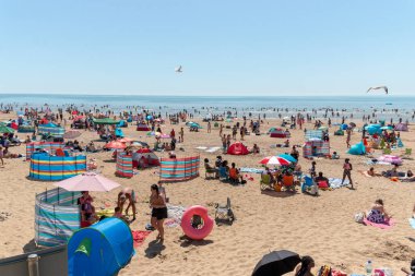 Kent-August-2020-İngiltere. Kent, İngiltere 'de çok sıcak bir yaz gününde kalabalık bir Camber plajı manzarası. 