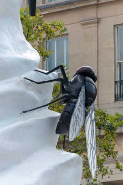 Londra-Ağustos-2020-İngiltere. Trafalgar Meydanı 'ndaki bir dondurma heykelinin üzerinde duran büyük plastik bir sineğin yakın görüntüsü.