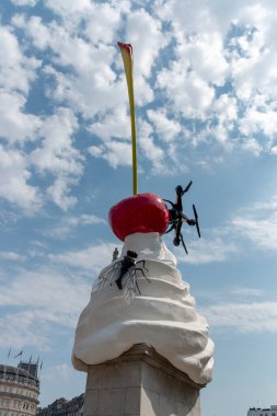 Londra-Ağustos-2020-İngiltere. Büyük bir plastik sinek ve Trafalgar Meydanı 'ndaki bir dondurma heykelinin üzerinde duran bir boğulma görüntüsü.