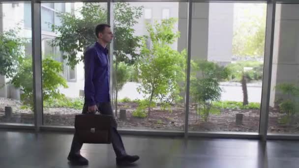 出勤途中にオフィスビルを横切ってブリーフケースを持ったビジネスマン — ストック動画