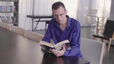 İş adamı vurdu bir kütüphane açık bir kitap okuma yavaş hareket