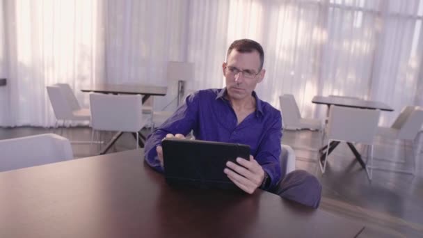 Boş Bir Kafede Bir Tablet Üzerinde Çalışan Adamı — Stok video