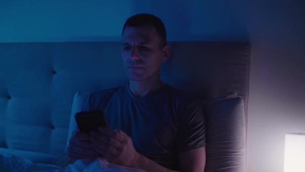 Allvarlig Man Sin Smartphone Medan Sängen — Stockvideo