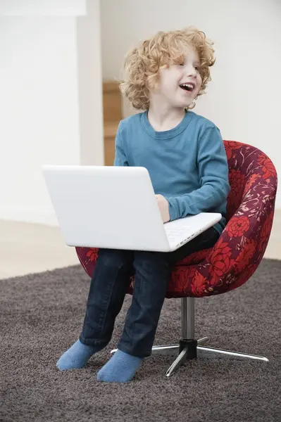Wesoły Chłopak Blond Włosach Pomocą Laptopa Fotel Domu — Zdjęcie stockowe