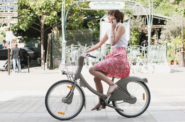 Γυναίκα Ιππασία Ποδήλατο Και Μιλάμε Για Ένα Κινητό Τηλέφωνο Παρίσι — Φωτογραφία Αρχείου