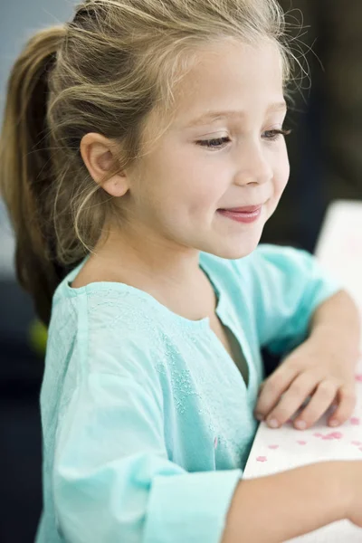책상에 서있는 웃고있는 소녀의 클로즈업 — 스톡 사진