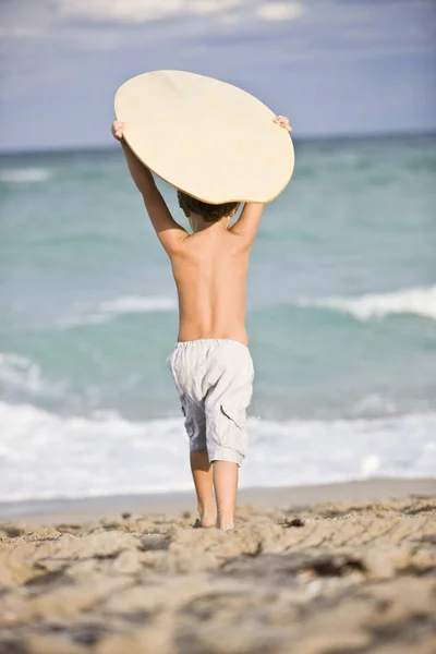 해변에서 보드를 소년의 뒷모습 — 스톡 사진