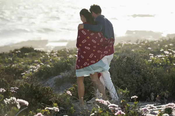 拥抱在阳光明媚的海岸散步的夫妇 — 图库照片