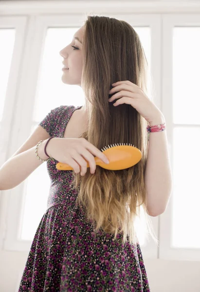 Adolescente Menina Escovando Cabelo Frente Janela — Fotografia de Stock