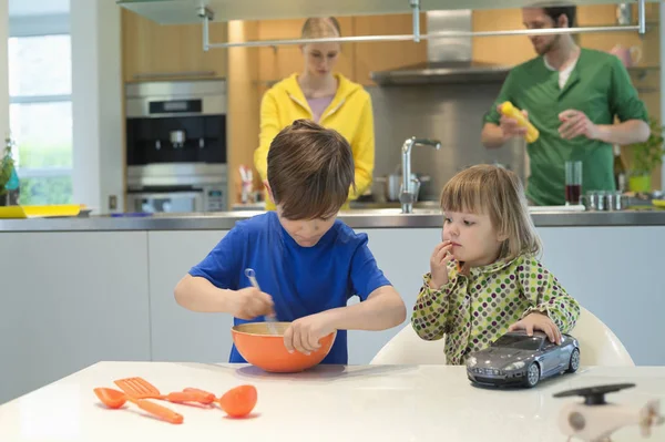 Menina Com Carro Brinquedo Olhando Para Irmão Cozinhar Cozinha — Fotografia de Stock