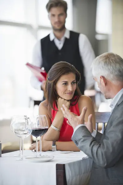 Casal Discutindo Restaurante Com Garçom Segundo Plano — Fotografia de Stock