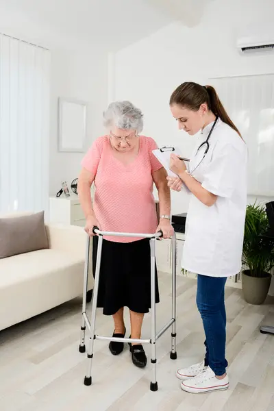 Giovane Medico Che Controlla Progresso Medico Riabilitazione Donna Anziana Casa — Foto Stock