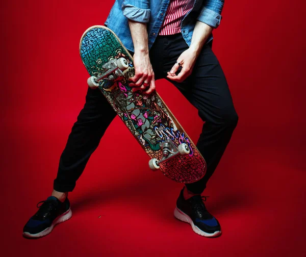 Un gars avec un skateboard sur un fond lumineux, un style jeune — Photo