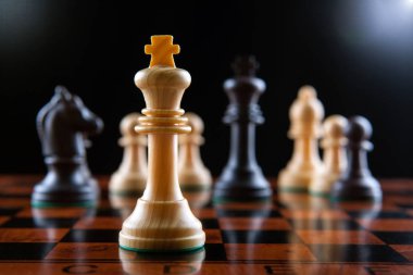 Satranç taşları bir satranç tahtası tablo ve siyah bir zemin üzerine kral bir satranç parça kapat