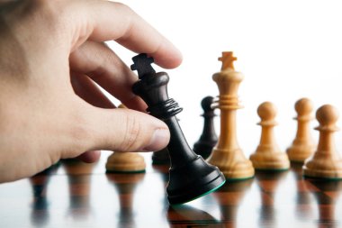 Satranç oyuncunun eli kara kral ve yenilgi satranç parça tutar