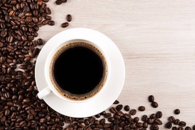 beyaz fincan kahve kahve çekirdekleri ahşap zemin ile yakın çekim