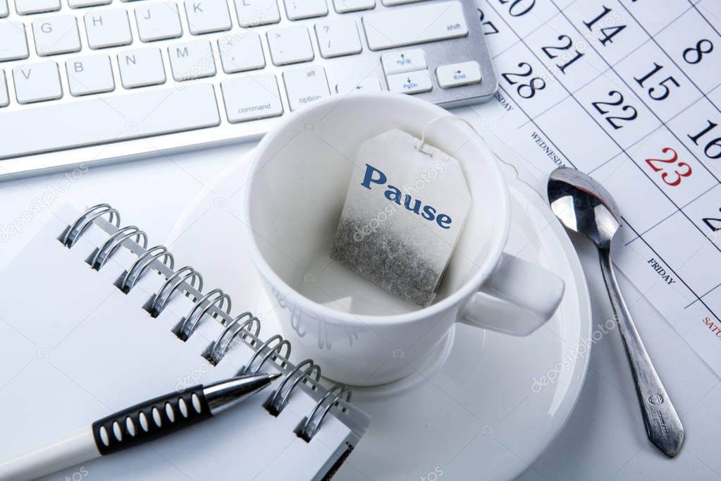 business still life of a cup with a tea bag on the desktop close up