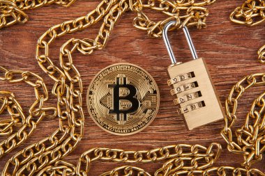 asma kilit bir ahşap zemin üzerinde altın bir zincir üzerinde altın sikke bitcoin, yakın çekim
