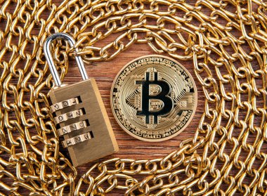 asma kilit bir ahşap zemin üzerinde altın bir zincir üzerinde altın sikke bitcoin, yakın çekim