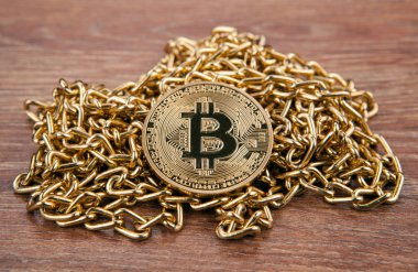 altın madeni para bitcoin bir ahşap zemin üzerinde altın bir zincir üzerinde Kapat