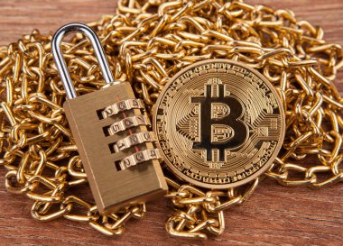 asma kilit bir ahşap zemin üzerinde altın bir zincir üzerinde altın sikke bitcoin, yakın çekim
