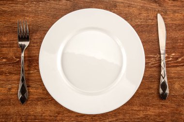 beyaz bir tabak, çatal ve bıçak üstten görünüm şeklinde mutfak eşyaları