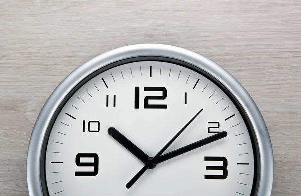 Cara Relógio Branco Com Dígitos Pretos Fundo Cinza Madeira Close — Fotografia de Stock